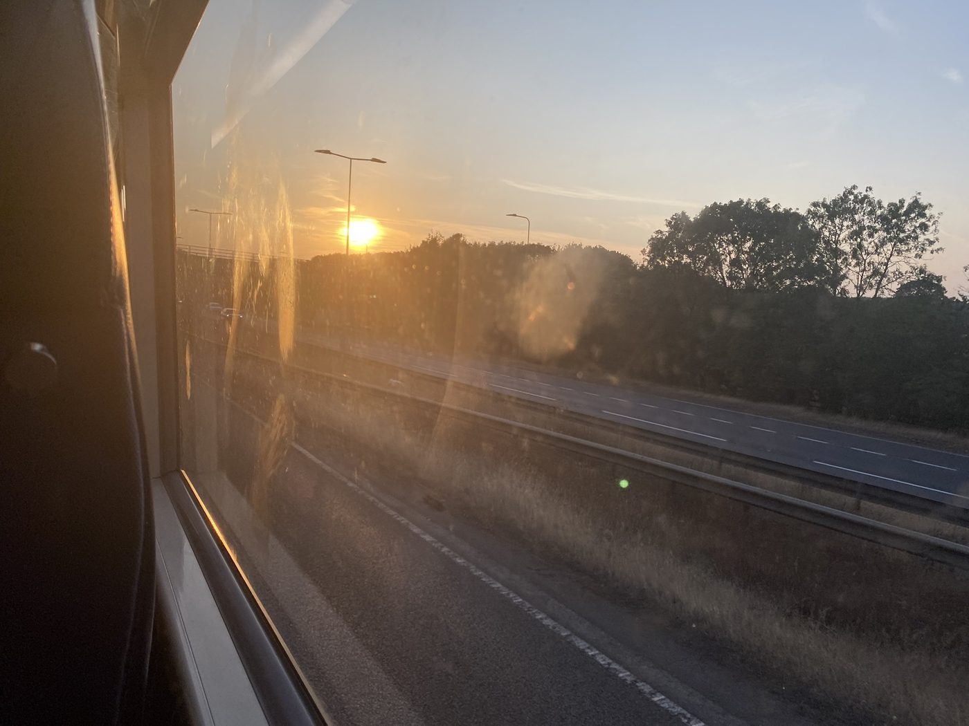 Sunset through a bus window over a motorway