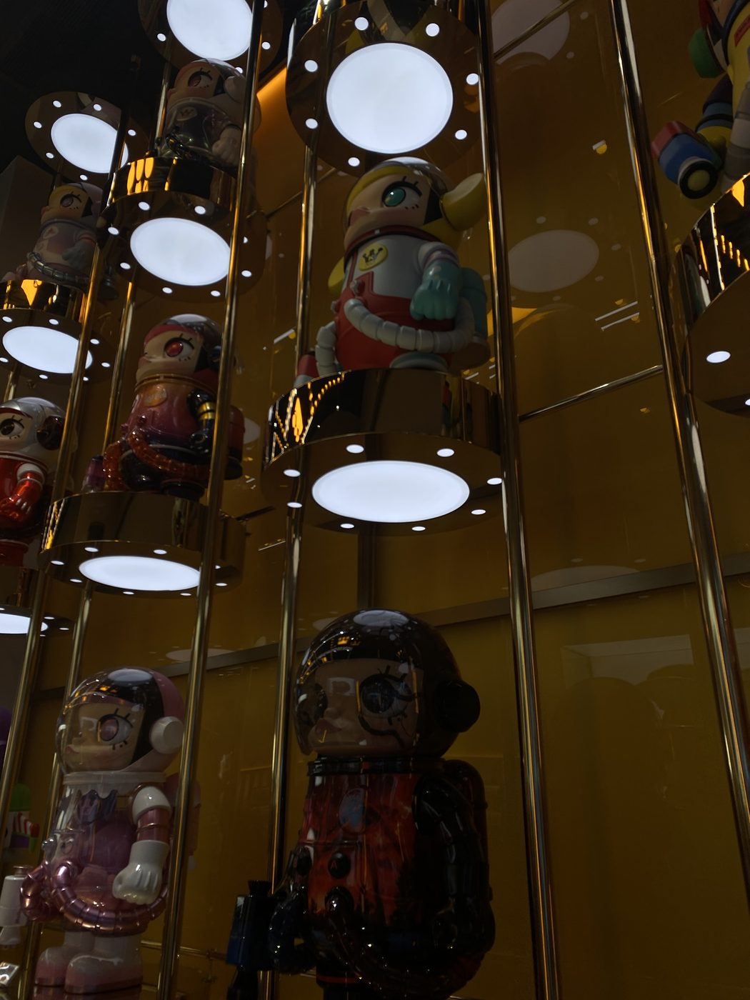 Astronaut figures lit up on gold display shelves